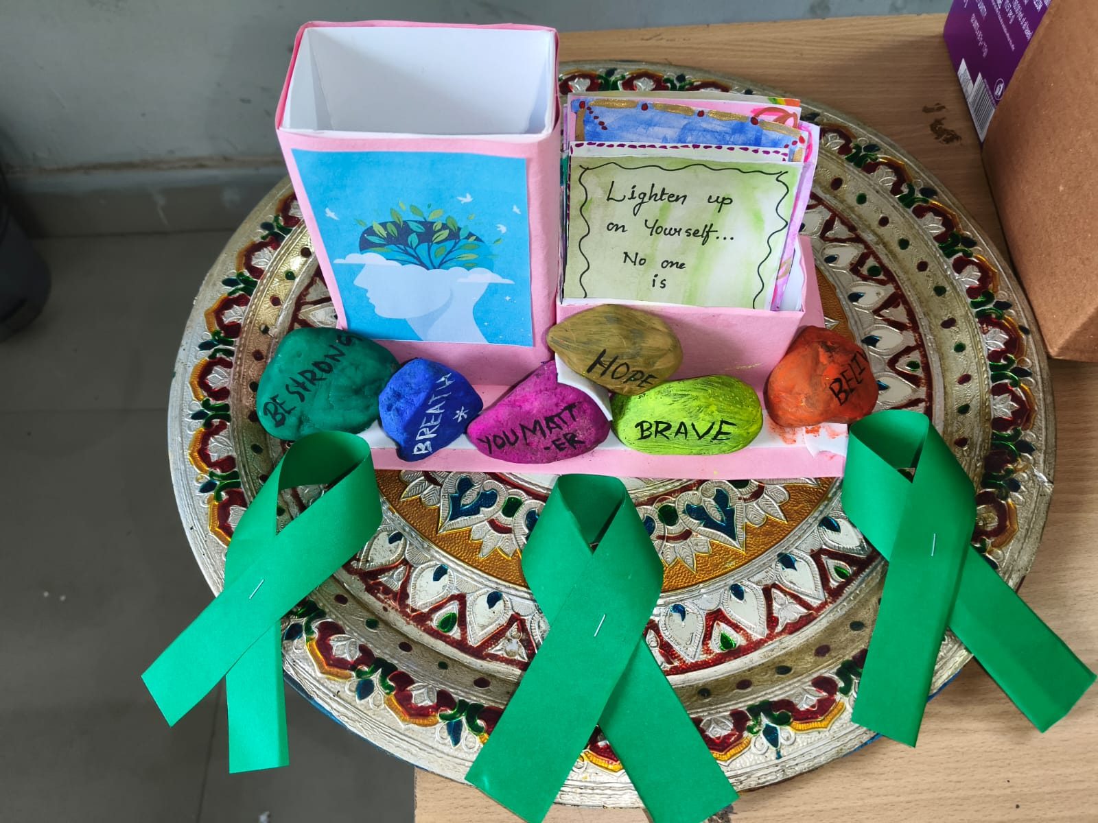 Green ribbons and painted kindness stones with words like Brave and Strong